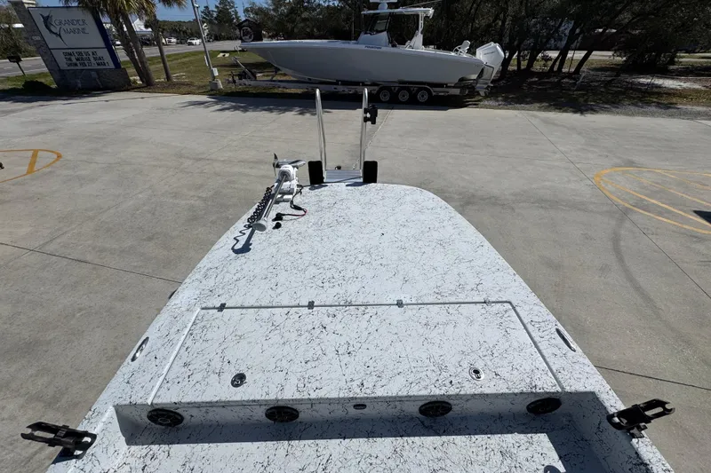 Slide: The Image of 2023 Dek Kat 27 Trilogy boat on concrete lot, showcasing deck and equipment. - 17