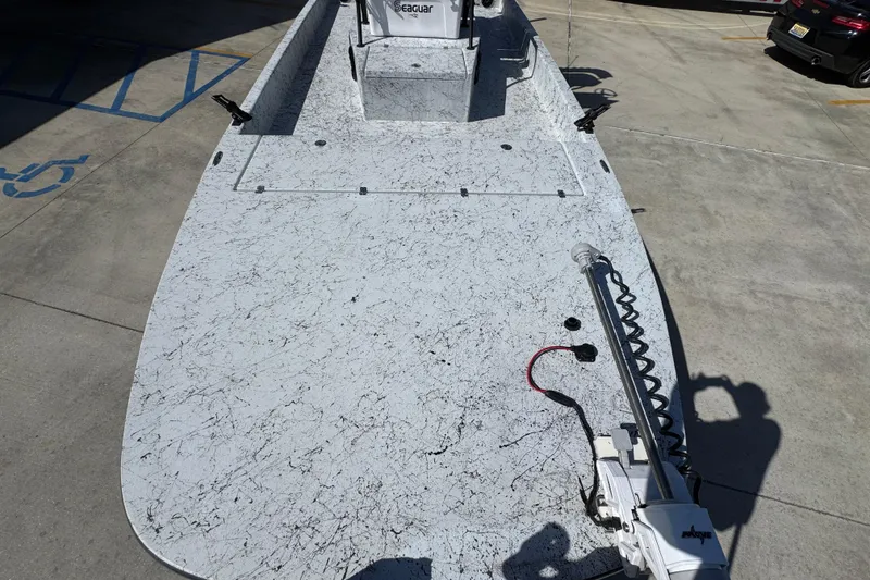 Slide: The Image of 2023 Dek Kat 27 Trilogy boat with textured deck, parked in a lot. - 20