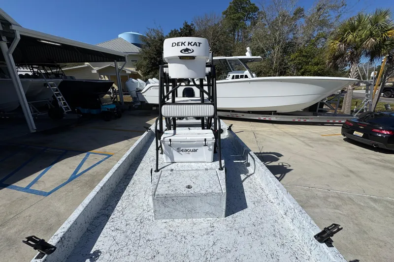 Slide: The Image of 2023 Dek Kat 27 Trilogy boat in marina, featuring elevated seating and modern design. - 22