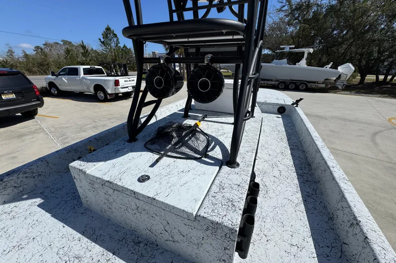 Slide: The Image of 2023 Dek Kat 27 Trilogy boat with fishing gear on deck, parked near vehicles. - 28