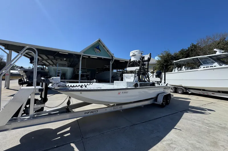 Slide: The Image of 2023 Dek Kat 27 Trilogy boat on trailer in sunny marina setting. - 3