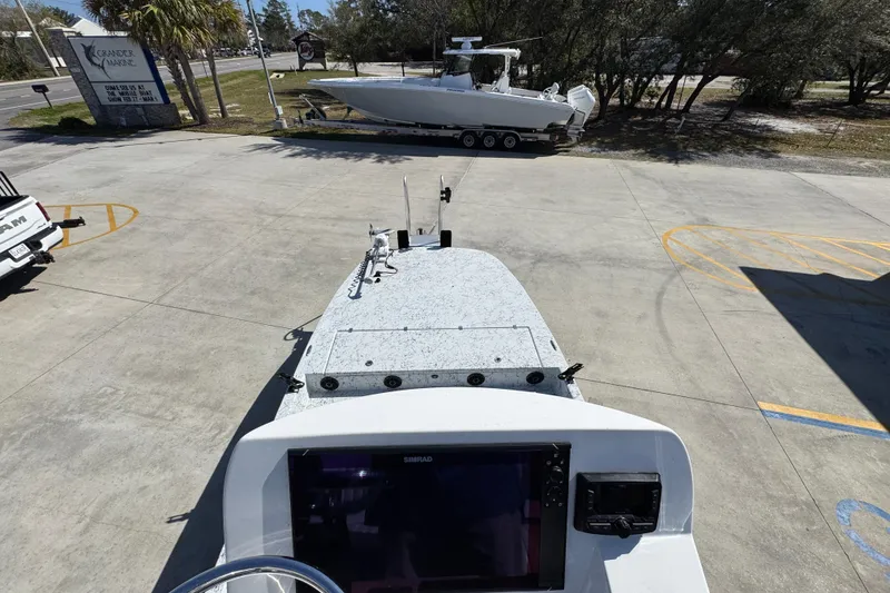 Slide: The Image of 2023 Dek Kat 27 Trilogy boat parked outdoors, featuring advanced navigation equipment. - 32