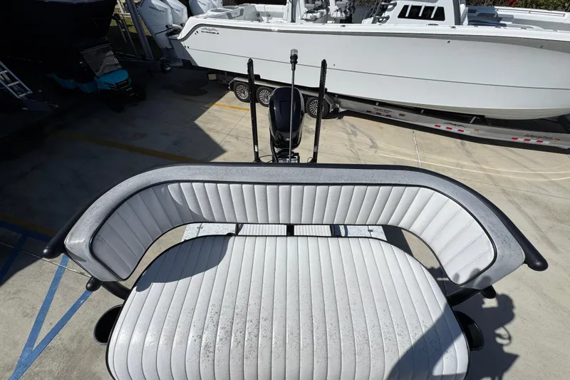 Slide: The Image of 2023 Dek Kat 27 Trilogy boat seat, white upholstery, docked beside another boat. - 33