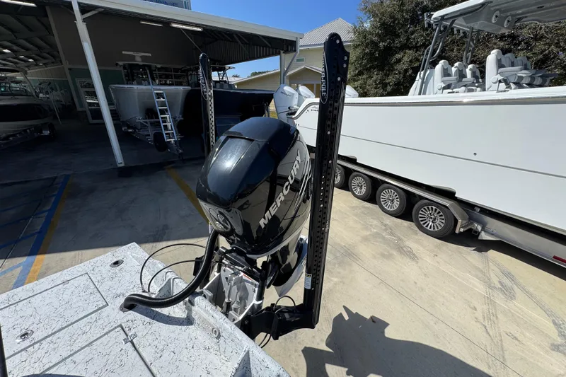 Slide: The Image of 2023 Dek Kat 27 Trilogy boat with Mercury engine, parked on a trailer. - 39