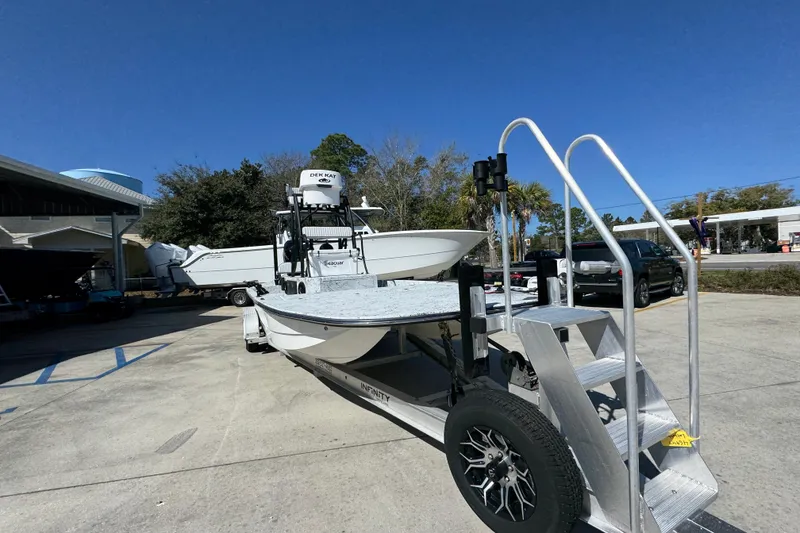 Slide: The Image of 2023 Dek Kat 27 Trilogy boat on trailer under clear blue sky. - 6