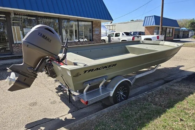 Slide: The Image of 2025 Tracker Grizzly 2072 Utility boat with Yamaha motor on trailer, parked outside. - 2