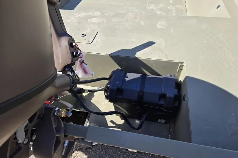 Slide: The Image of 2025 Tracker Grizzly 2072 Utility boat battery compartment with wiring and motor components. - 5