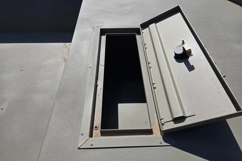 Slide: The Image of Open storage compartment on 2025 Tracker Grizzly 2072 Utility boat deck. - 9