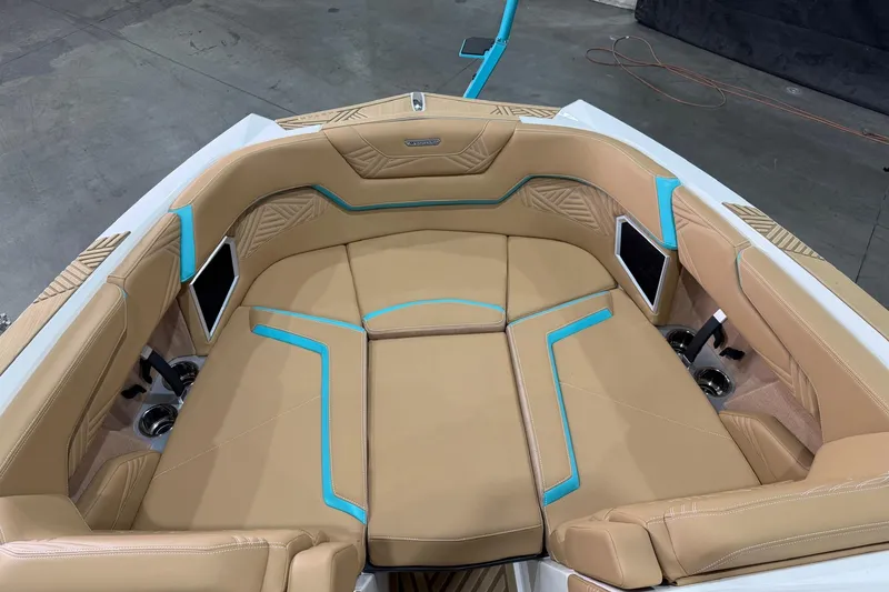 Slide: The Image of 2025 MasterCraft XStar 23 boat interior with tan and blue seating, modern design. - 12