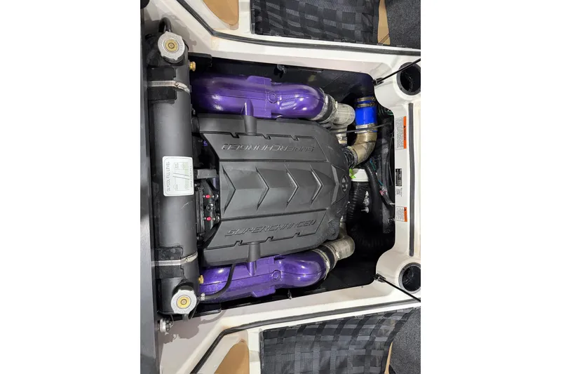 Slide: The Image of 2025 MasterCraft XStar 23 engine with purple components and black cover. - 14