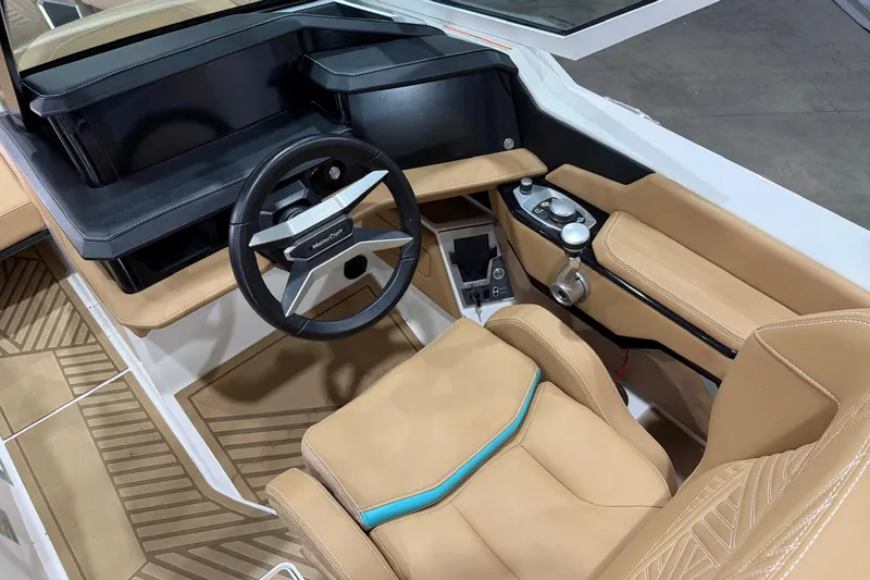Slide: The Image of 2025 MasterCraft XStar 23 boat interior with tan seats and modern steering wheel. - 9