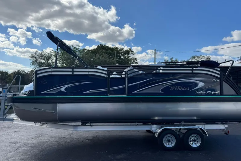 The Image of 2026 JC 23 Neptoon TT Sport pontoon boat on trailer under a blue sky. - 7