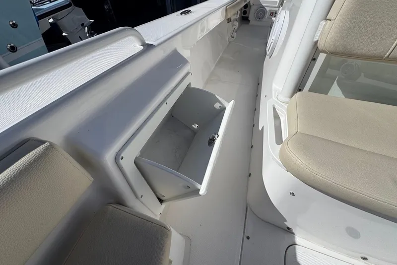 Slide: The Image of 2015 Everglades 243 Center Console boat interior with open storage compartment and seating. - 13