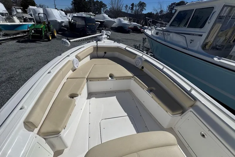 Slide: The Image of 2015 Everglades 243 Center Console boat with beige seating, docked outdoors. - 15