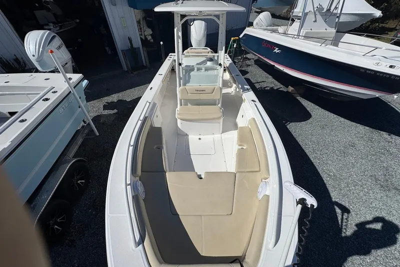 Slide: The Image of 2015 Everglades 243 Center Console boat with beige seating, docked outdoors. - 16