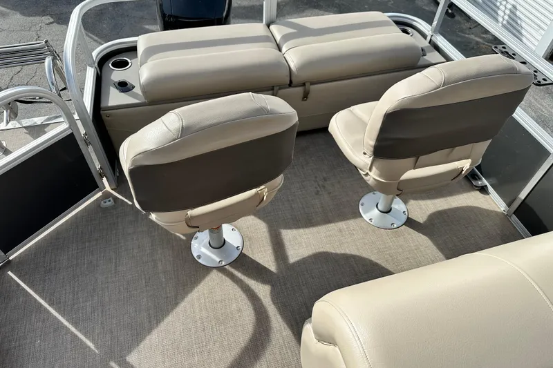 Slide: The Image of 2023 SUNTRACKER XP3 Fishin' 22 Barge DLX interior with beige seating and cup holders. - 8