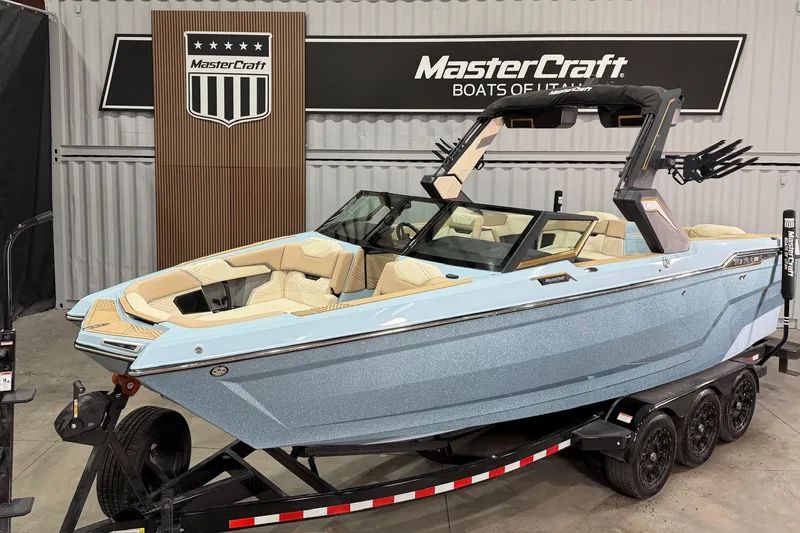 The Image of 2025 MasterCraft XStar 25 boat in showroom, featuring sleek design and luxury seating. - 1