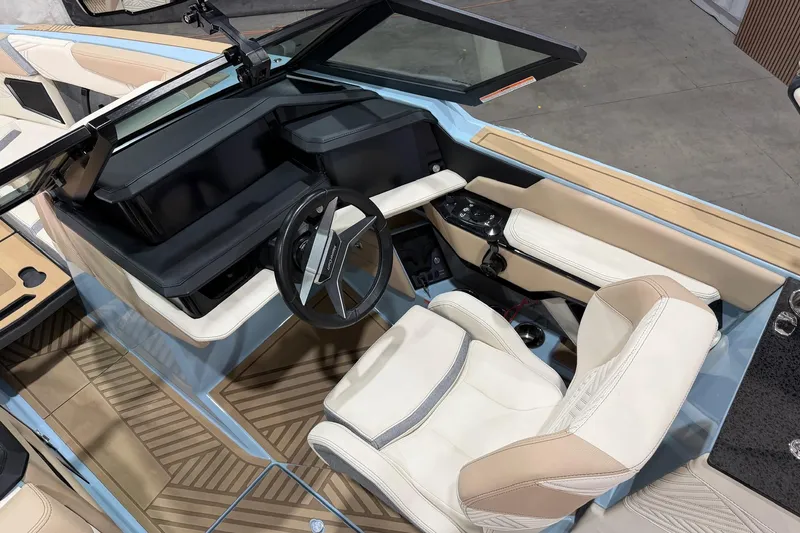 Slide: The Image of 2025 MasterCraft XStar 25 boat interior with modern steering and luxurious seating. - 11