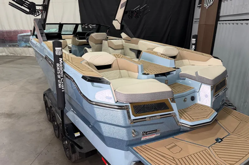Slide: The Image of 2025 MasterCraft XStar 25 boat with luxurious seating and sleek design in showroom. - 6
