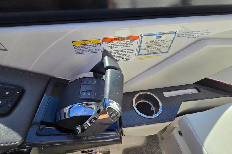 Slide: The Image of Control panel of a 2017 Formula 310 Sun Sport boat with warning labels and cup holder. - 100