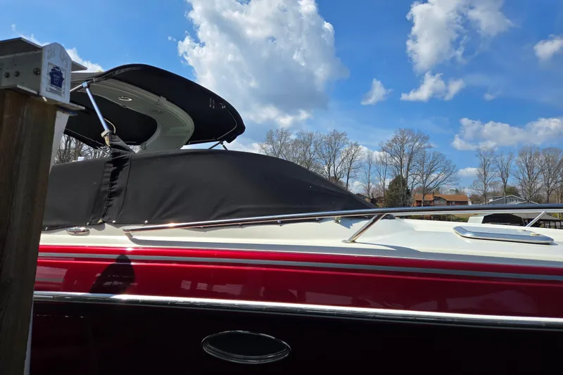 Slide: The Image of 2017 Formula 310 Sun Sport boat with black cover, under a blue sky with clouds. - 2