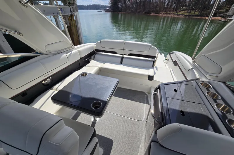 Slide: The Image of 2017 Formula 310 Sun Sport boat interior with seating and table on a lake. - 23