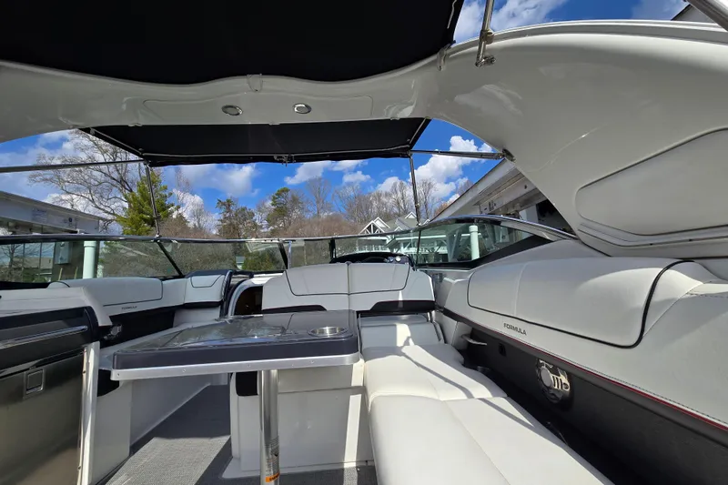 Slide: The Image of 2017 Formula 310 Sun Sport boat interior with sleek seating and table under a canopy. - 24