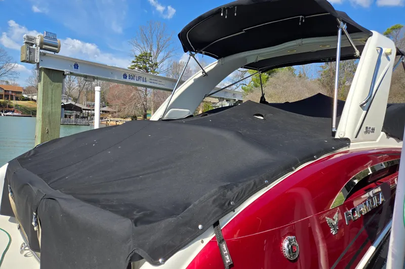 Slide: The Image of 2017 Formula 310 Sun Sport boat with black cover docked by a lake. - 3