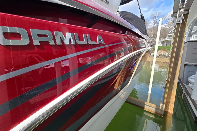 Slide: The Image of 2017 Formula 310 Sun Sport boat with red and black detailing docked by the water. - 4