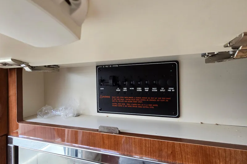 Slide: The Image of Control panel inside a 2017 Formula 310 Sun Sport boat, featuring various switches and warnings. - 63