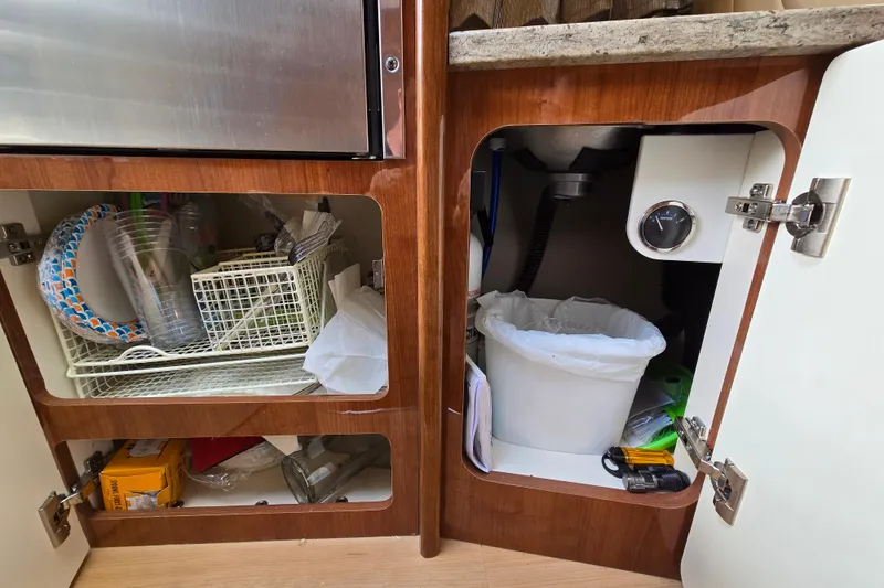 Slide: The Image of Cabinet storage in 2017 Formula 310 Sun Sport boat with kitchen supplies and trash bin. - 66