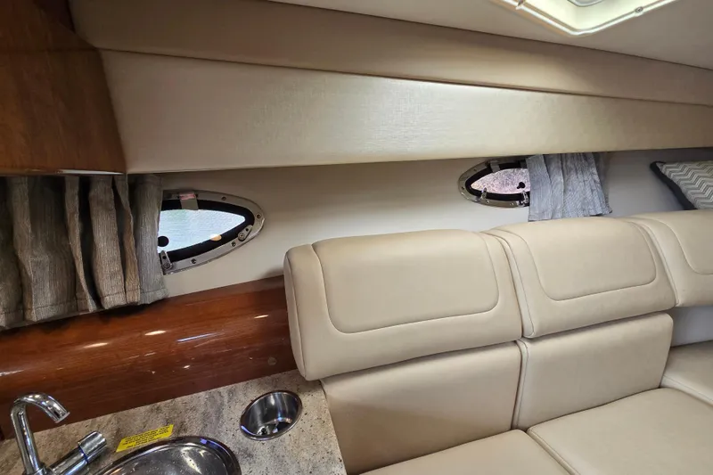 Slide: The Image of 2017 Formula 310 Sun Sport interior with beige seating, portholes, and countertop sink. - 69