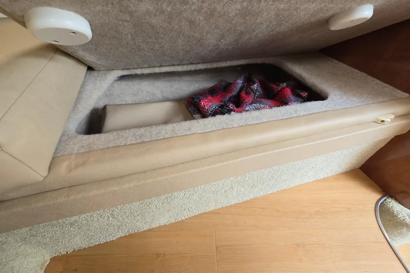 Slide: The Image of 2017 Formula 310 Sun Sport interior storage compartment with beige upholstery and red blanket. - 77