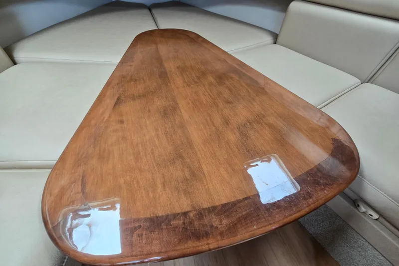 Slide: The Image of 2017 Formula 310 Sun Sport cabin with wooden table and beige seating. - 79