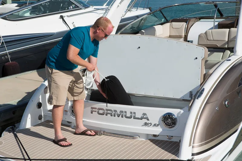 Slide: The Image of Manufacturer Provided Image: Man on a 2017 Formula 310 Sun Sport boat, organizing storage compartment. - 91