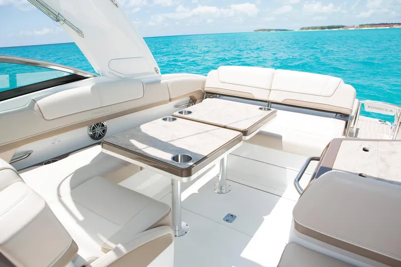 Slide: The Image of Manufacturer Provided Image: 2017 Formula 310 Sun Sport boat interior with seating and tables on turquoise water. - 92
