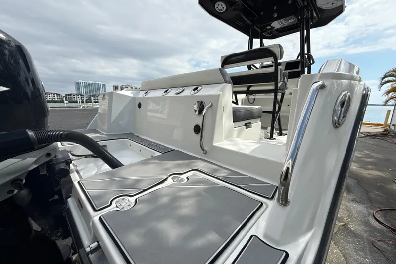 Slide: The Image of 2018 Blackfin 212 CC boat with sleek design, docked near waterfront buildings. - 14