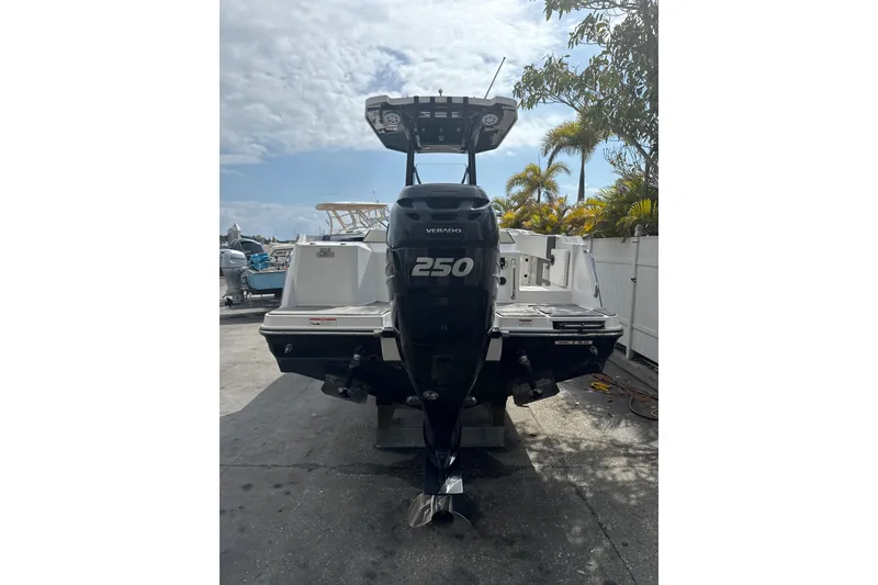 Slide: The Image of 2018 Blackfin 212 CC boat with a 250 Verado engine, parked outdoors. - 16
