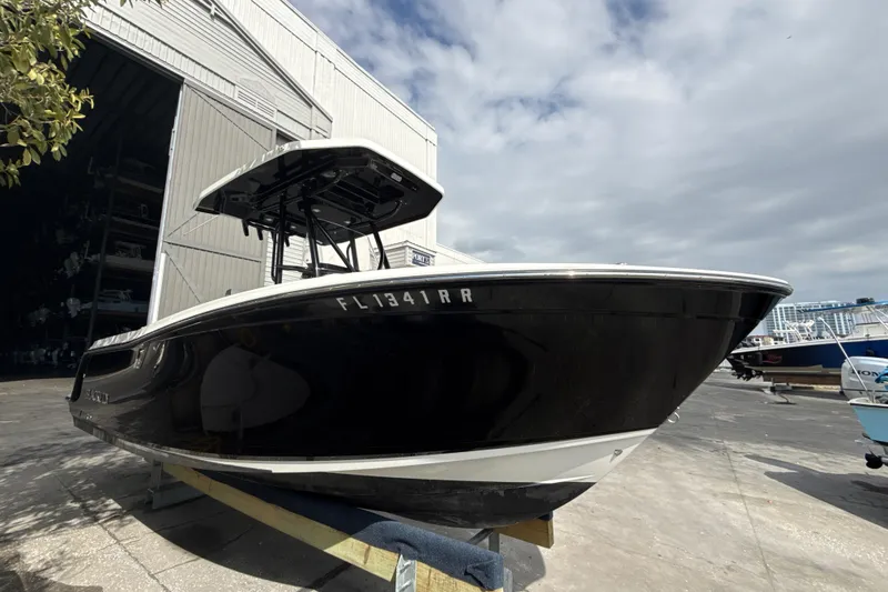 Slide: The Image of 2018 Blackfin 212 CC boat in a marina, under a cloudy sky. - 20