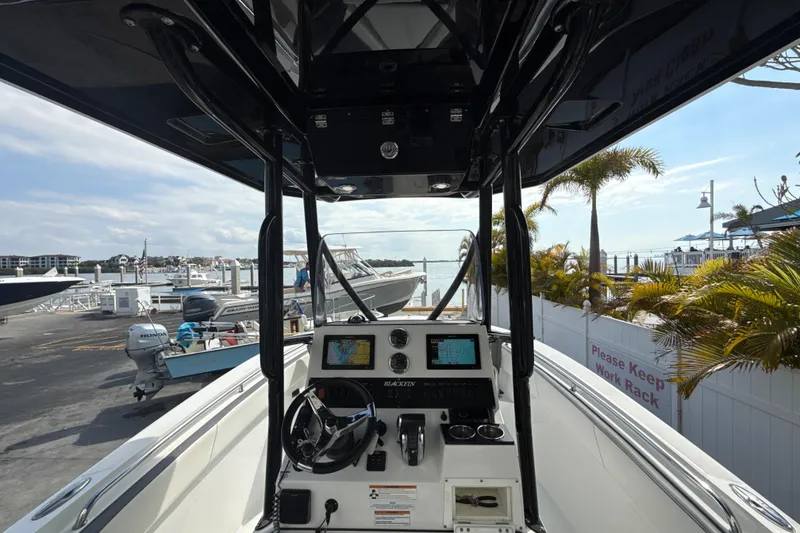 Slide: The Image of 2018 Blackfin 212 CC boat at marina, featuring modern dashboard and scenic waterfront view. - 3