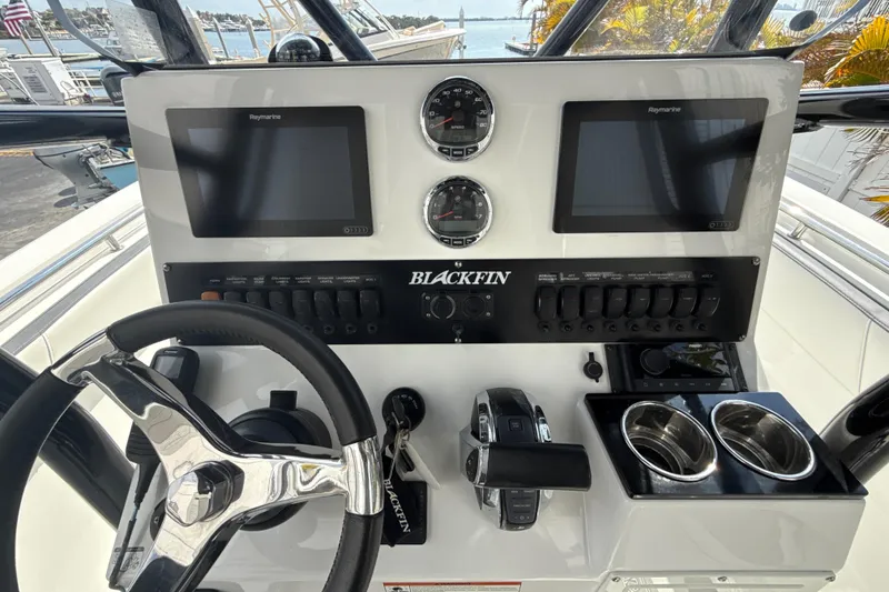 Slide: The Image of 2018 Blackfin 212 CC boat dashboard with steering wheel, dual screens, and control panel. - 4