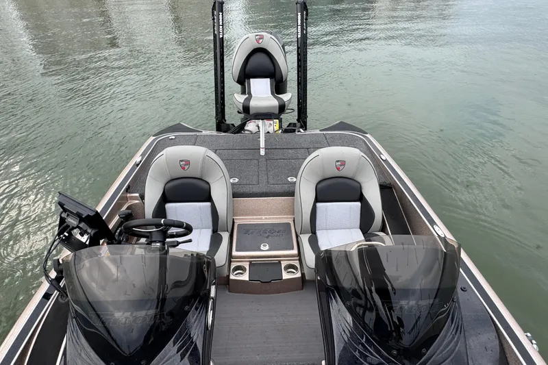 Slide: The Image of 2026 Triton 18 TrX boat interior with dual seats and steering wheel on calm water. - 12