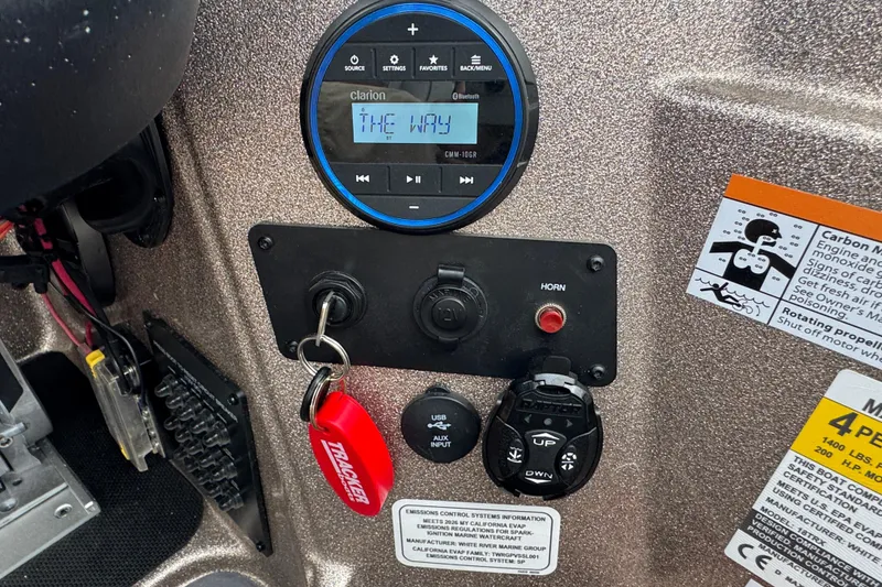Slide: The Image of Control panel of 2026 Triton 18 TrX boat with Clarion audio system and safety labels. - 18