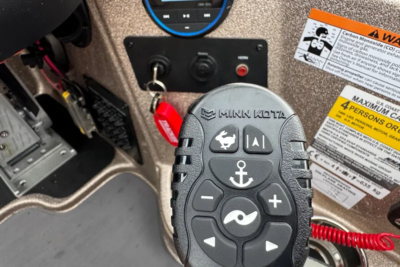 Slide: The Image of Remote control for Minn Kota trolling motor on 2026 Triton 18 TrX boat dashboard. - 19