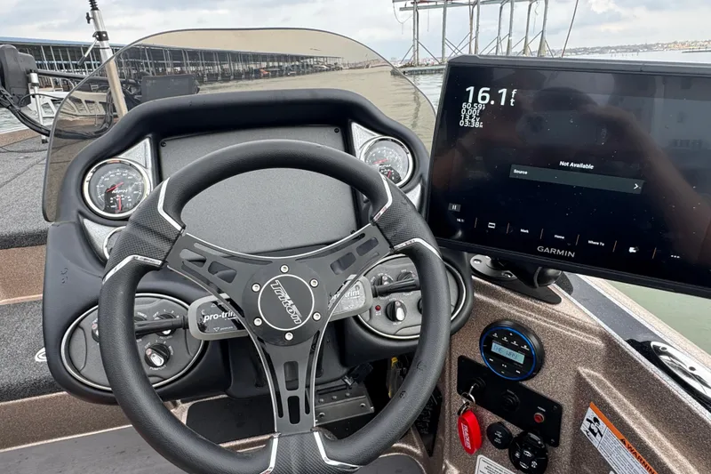 Slide: The Image of 2026 Triton 18 TrX boat dashboard with steering wheel and Garmin display. - 21