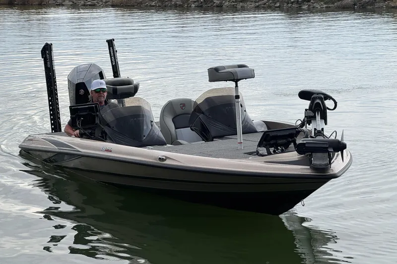Slide: The Image of 2026 Triton 18 TrX bass boat on calm water, featuring advanced fishing equipment. - 3