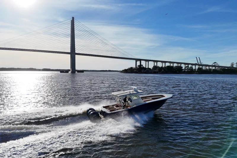 Slide: The Image of 2017 Scout 350 LXF boat cruising under a bridge on a sunny day. - 32