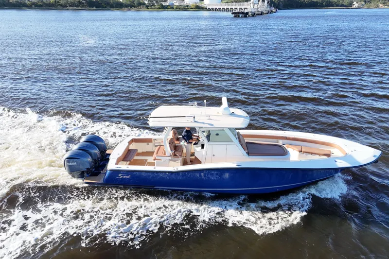Slide: The Image of 2017 Scout 350 LXF boat cruising on a river with dual Yamaha engines. - 33