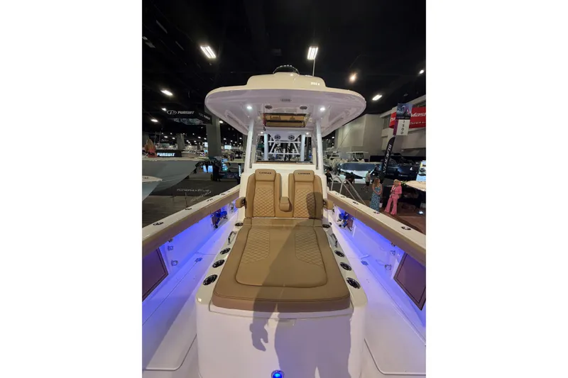 Slide: The Image of 2026 Caymas 29 CT boat interior with cushioned seating and ambient lighting at a boat show. - 5