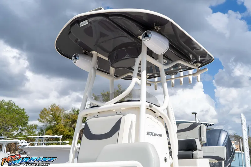 Slide: The Image of 2021 Skeeter SX2550 Family boat with T-top and speakers under cloudy sky. - 13